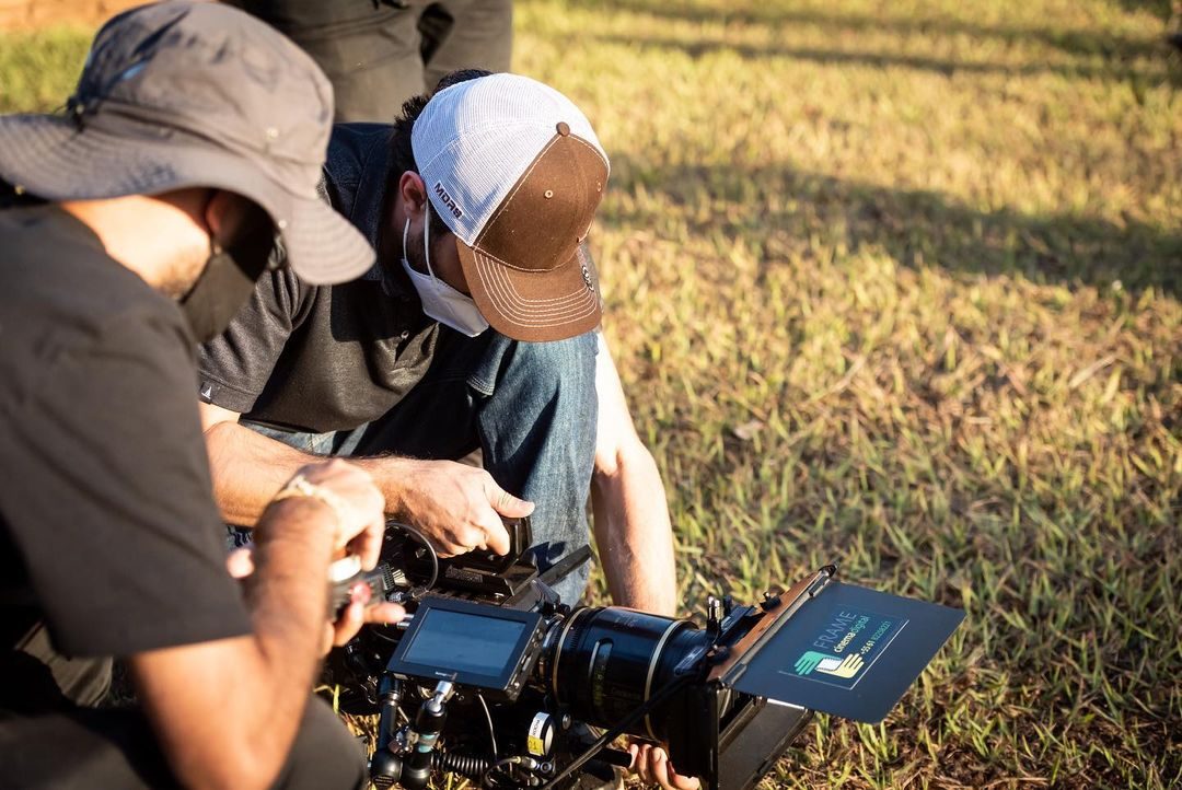 Equipe filmando em campo aberto com câmera de cinema