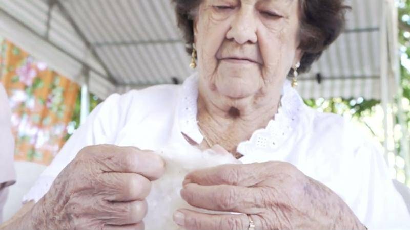 Mãos de uma fiandeira trabalhando o algodão